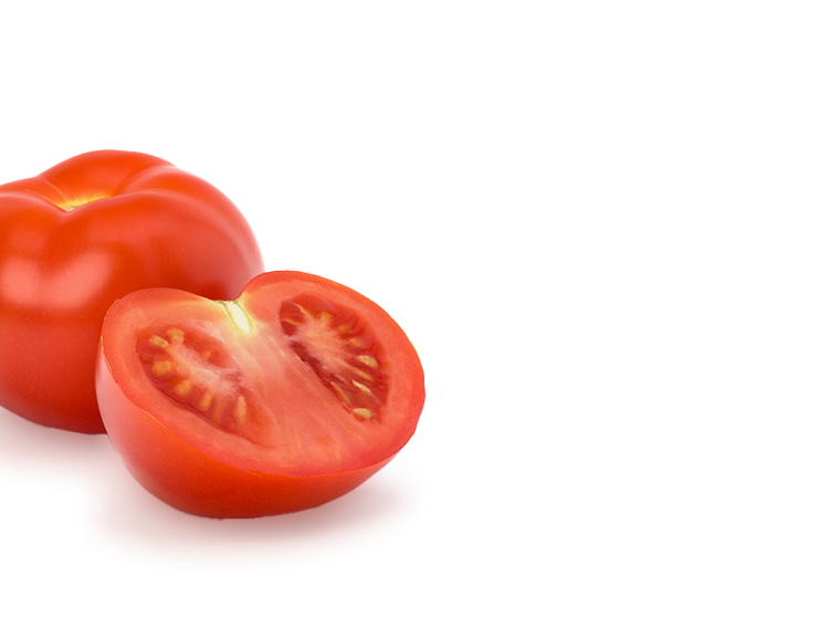 Halved tomato next to a whole tomato