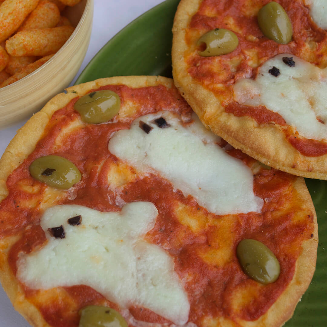 2 pizzas with topped with mozzarella shaped ghosts and green olives