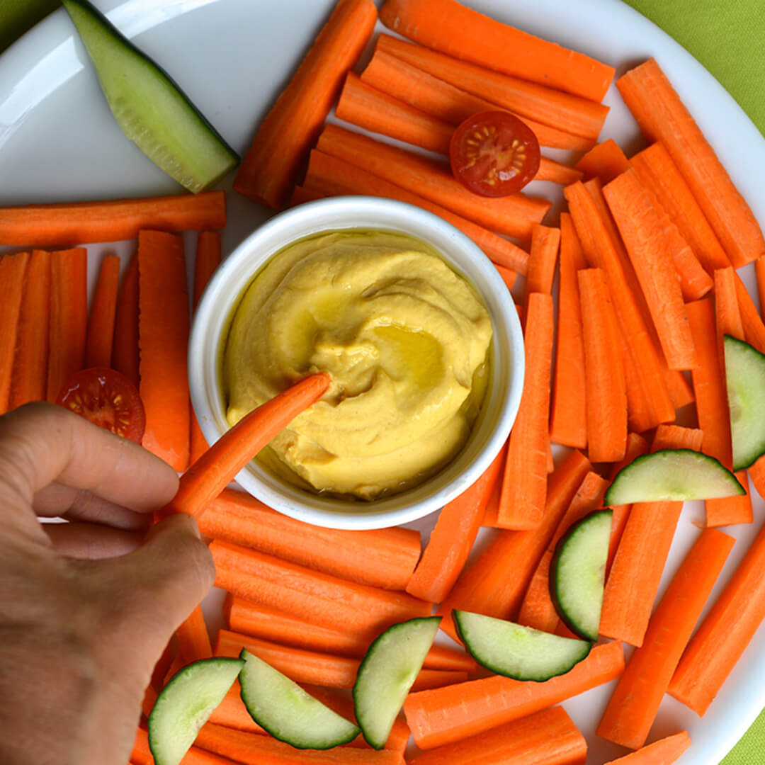 Pumpkin Face Platter made with carrots, cucumber and cherry tomato with a pumpkin hummus dip