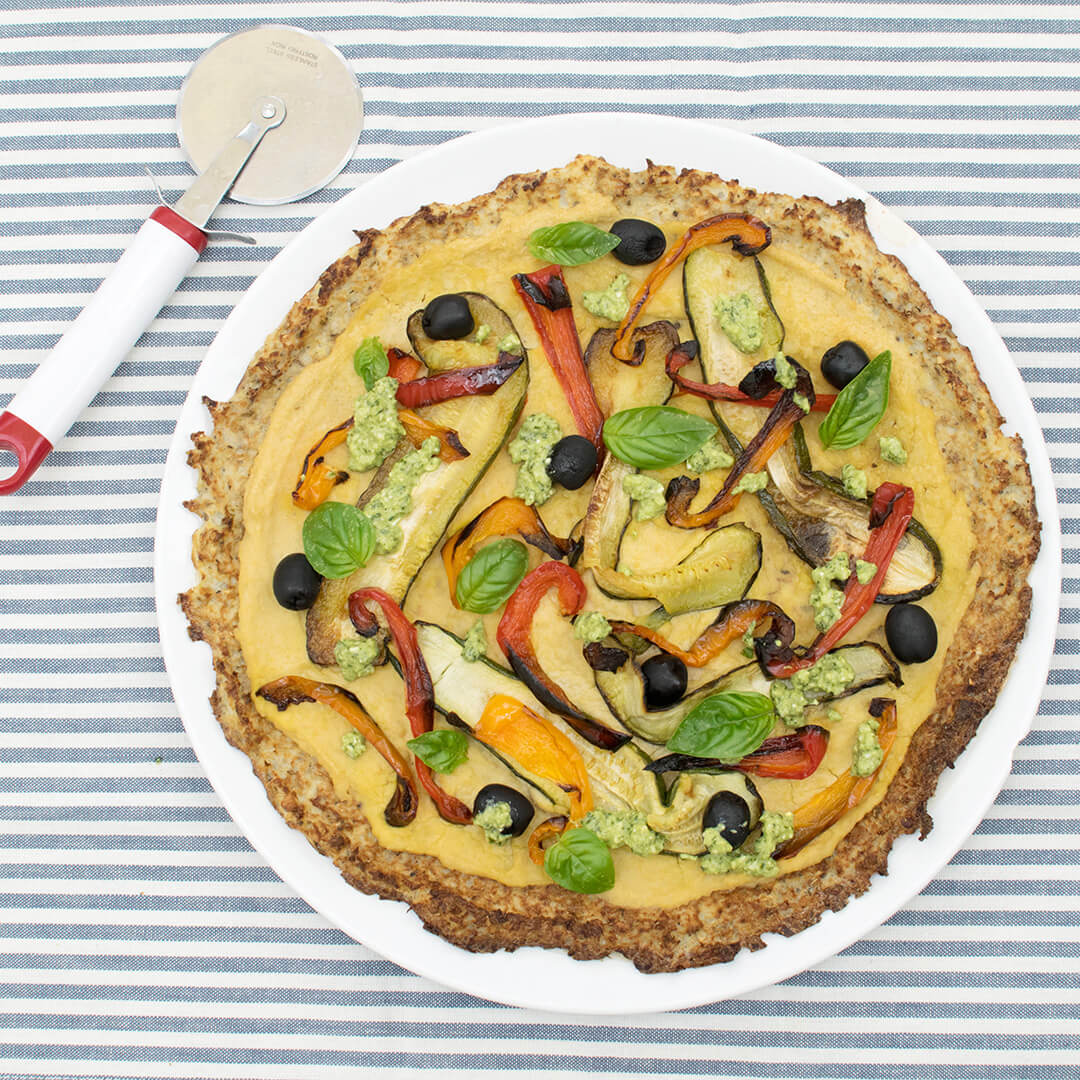 Roasted Veggie Cauliflower Pizza topped with red and yellow peppers, courgette and olives