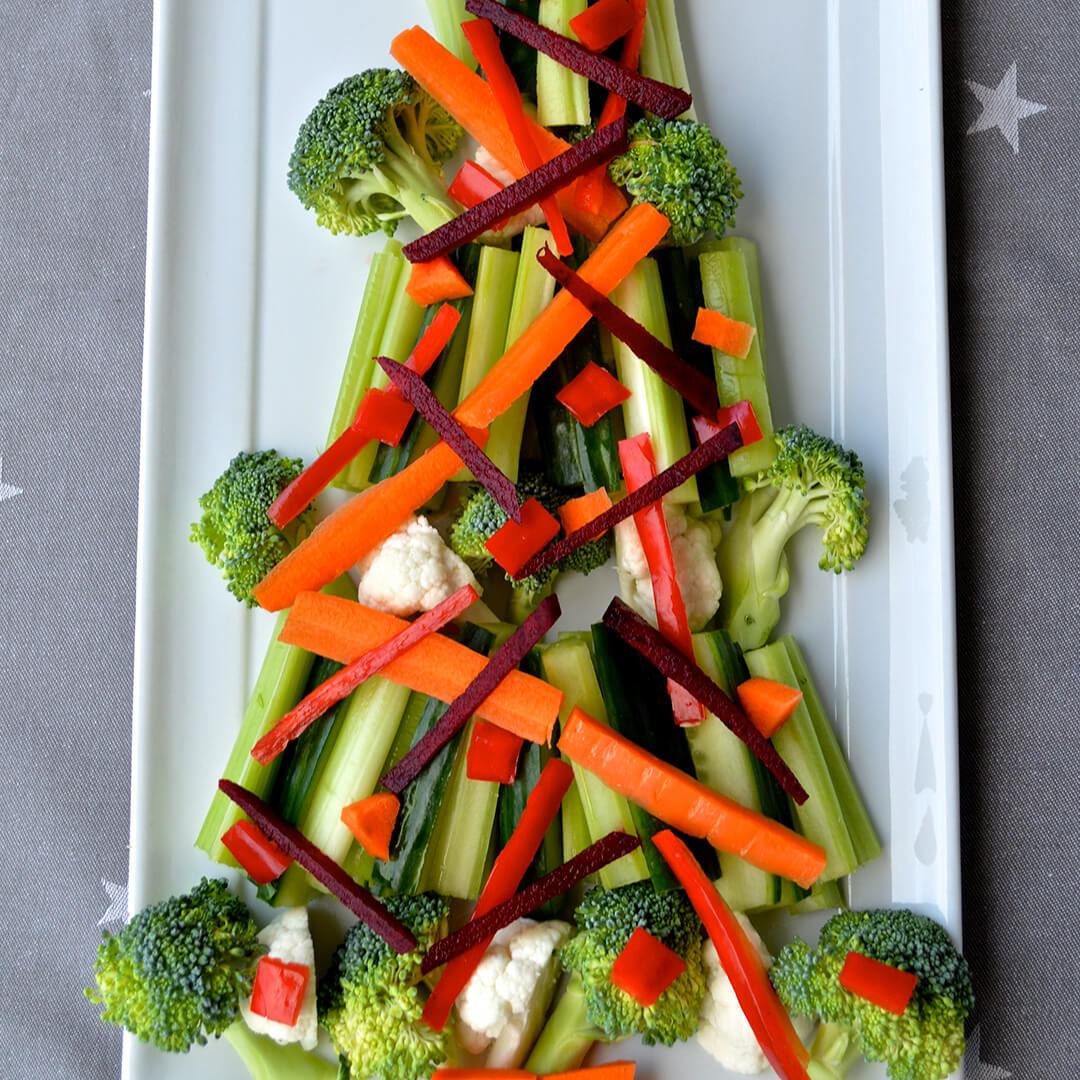 Veg Nibbles Christmas Tree made of cauliflower and broccoli florets, celery and cucumber sticks, carrots, red pepper and beetroot