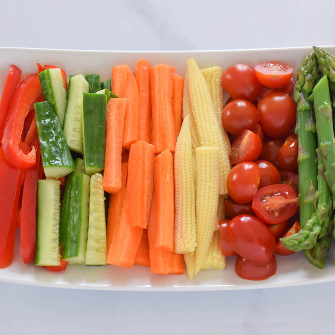 Veggie Crudités platter with red pepper, cucumber, carrot, baby corn, cherry tomatoes and asparagus tips
