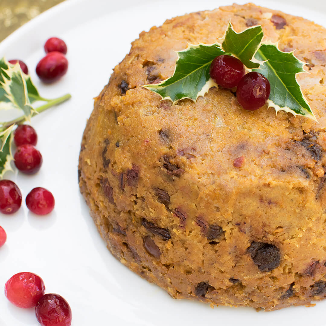 Christmas Pudding decorated with holly leaves and cranberries