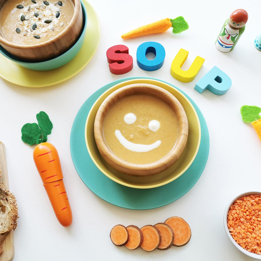 A bowl of lentil soup with a cream smiley face