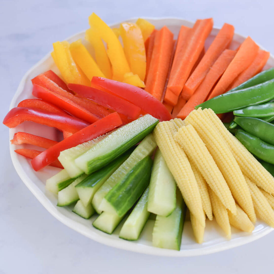 Rainbow Veggie Platter with carrot sticks, sugar snap peas, baby corn, cucumber sticks and sliced red and yellow peppers