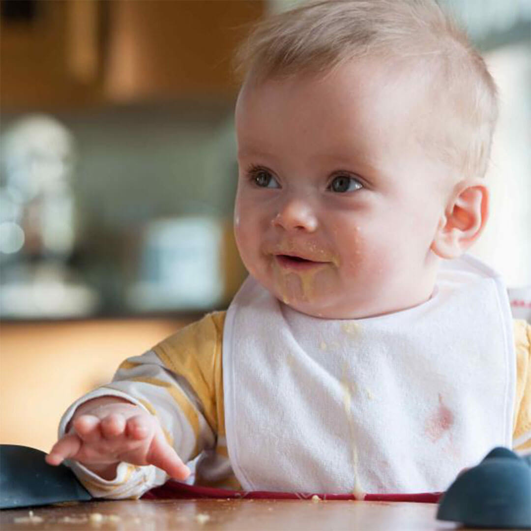 A smiling baby wearing a bib