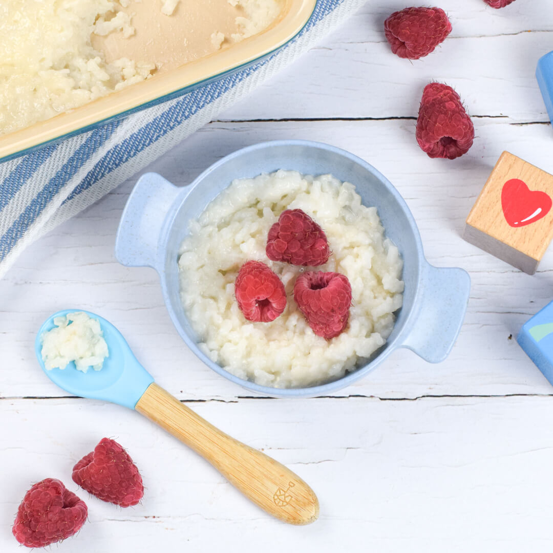 A small bowl of rice pudding topped with raspberries