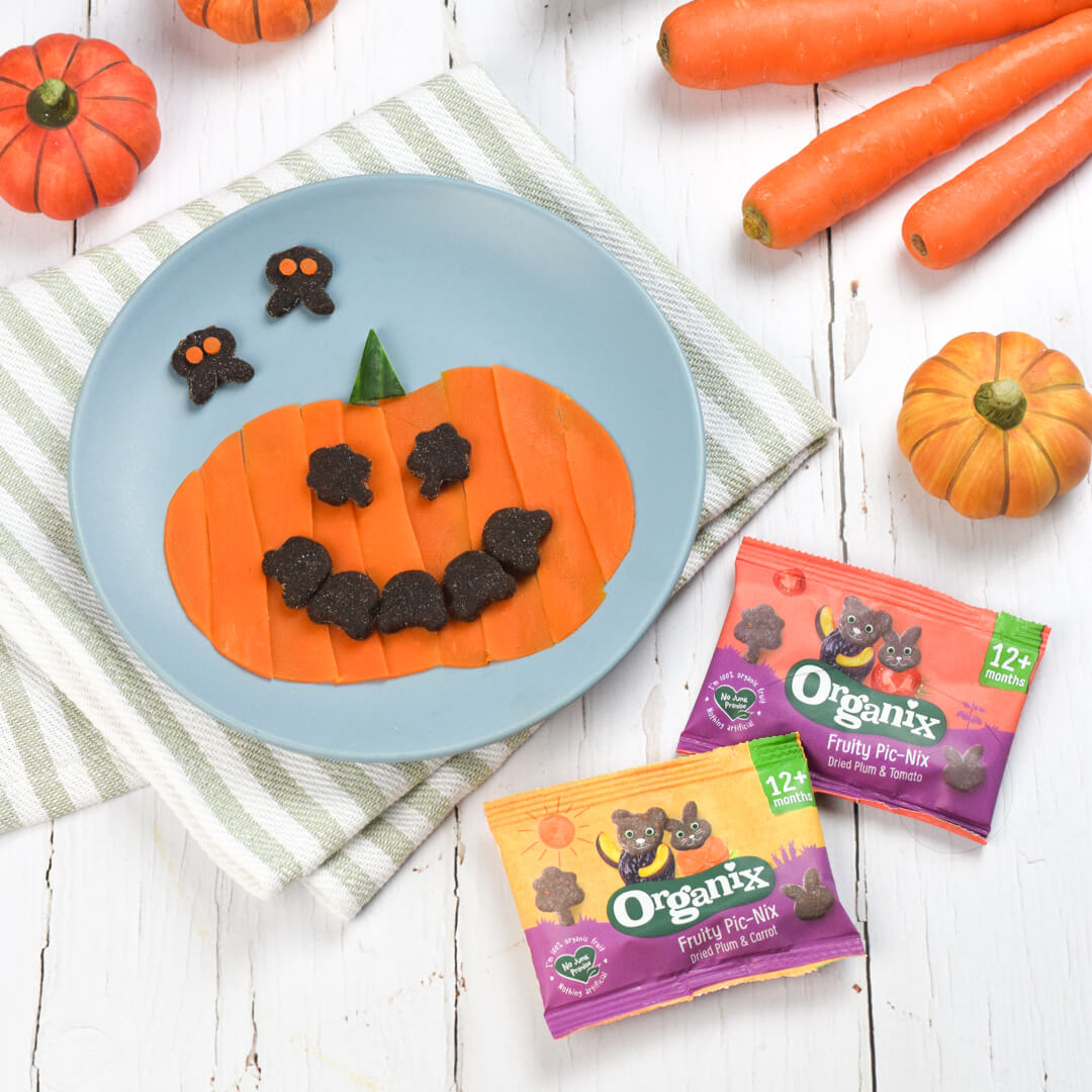 A fun plate with a pumpkin made of steamed carrot slices and Organix PicNix eyes and mouth. Cute PicNix decorate the plate. Seasonal vegetables decorate the plate.