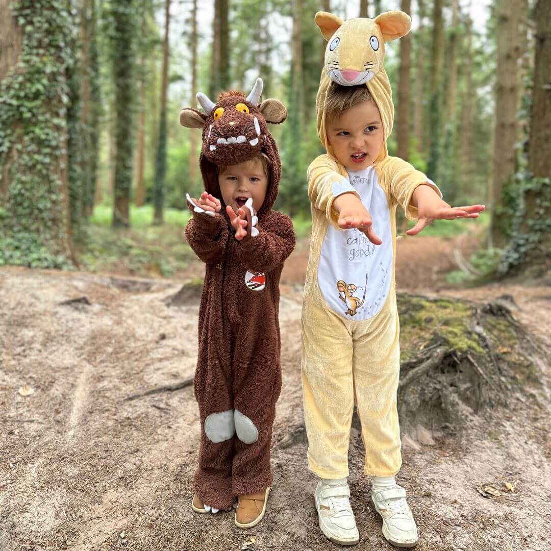 Two kids dressed in The Gruffalo characters pretending to roar