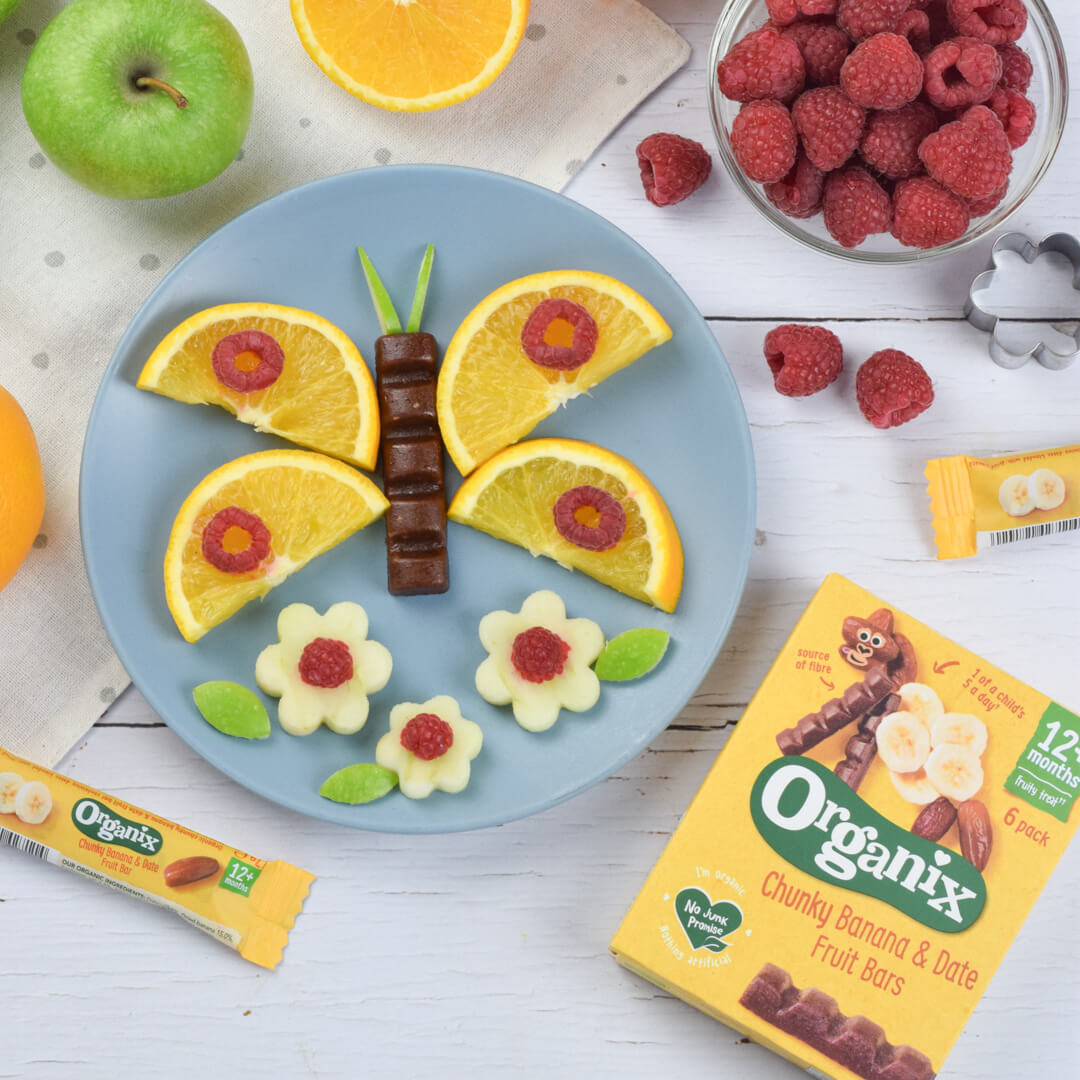 Organix chunky fruit bar used to recreate a butterfly, using chopped orange wedges as the wings, the Organix bar as the body and chopped apple, raspberries and mint leaves to look like flowers