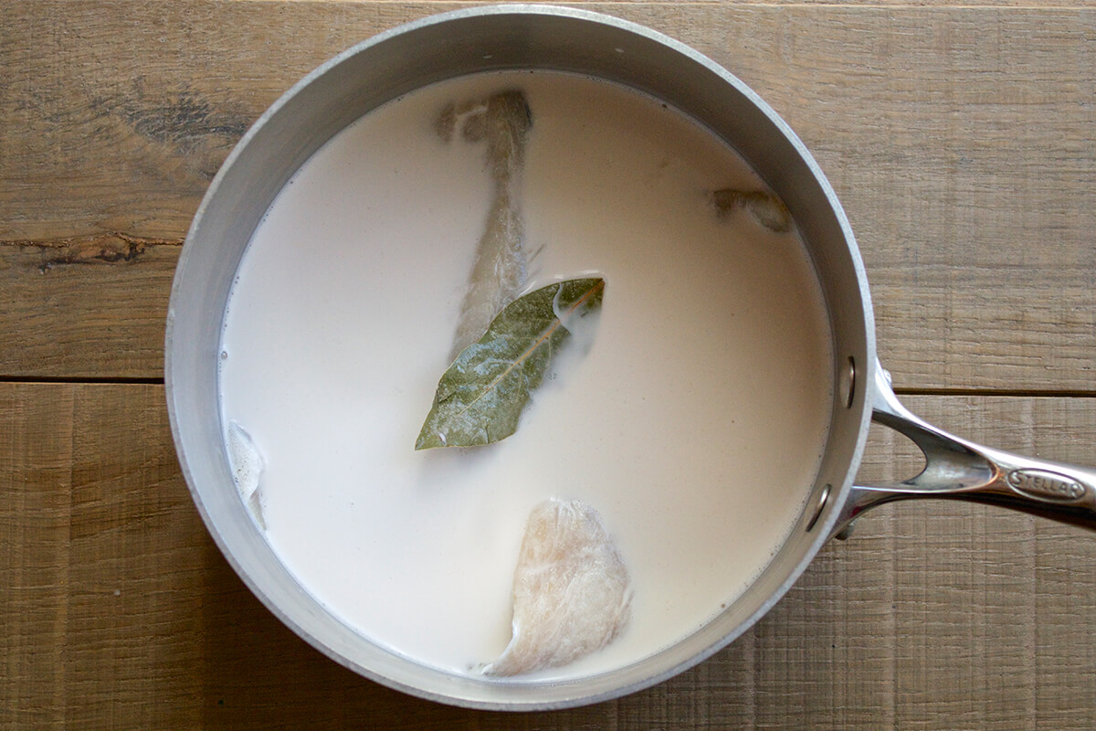 Fish in a saucepan with milk and a bay leaf