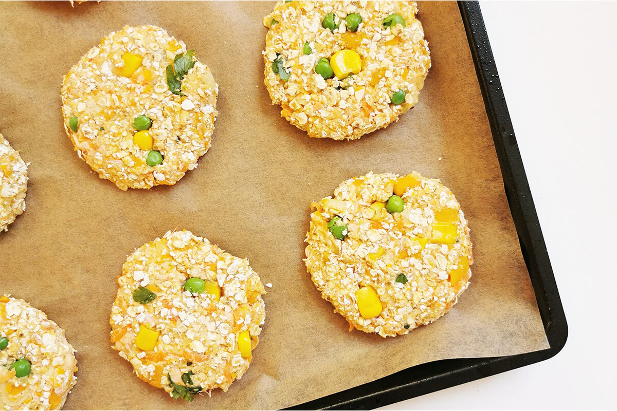 Uncooked salmon fishcakes on a lined baking tray