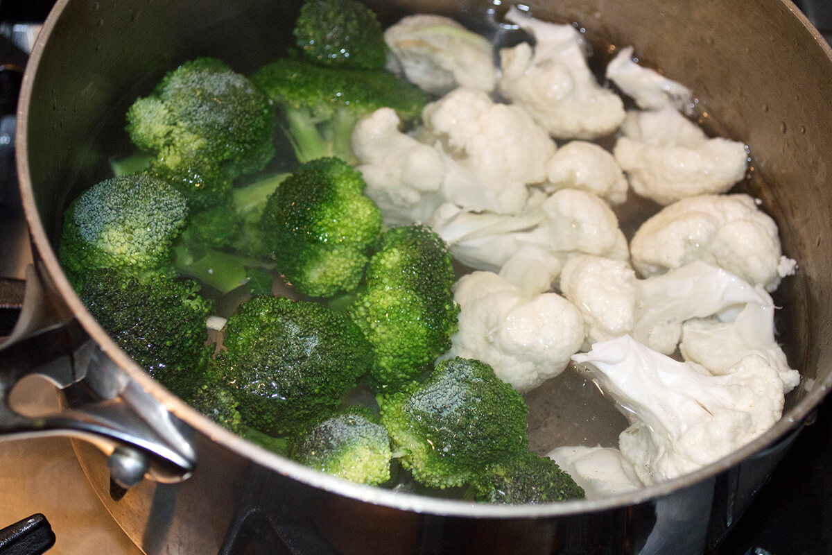 Broccoli and cauliflower being boiled in saucepan 