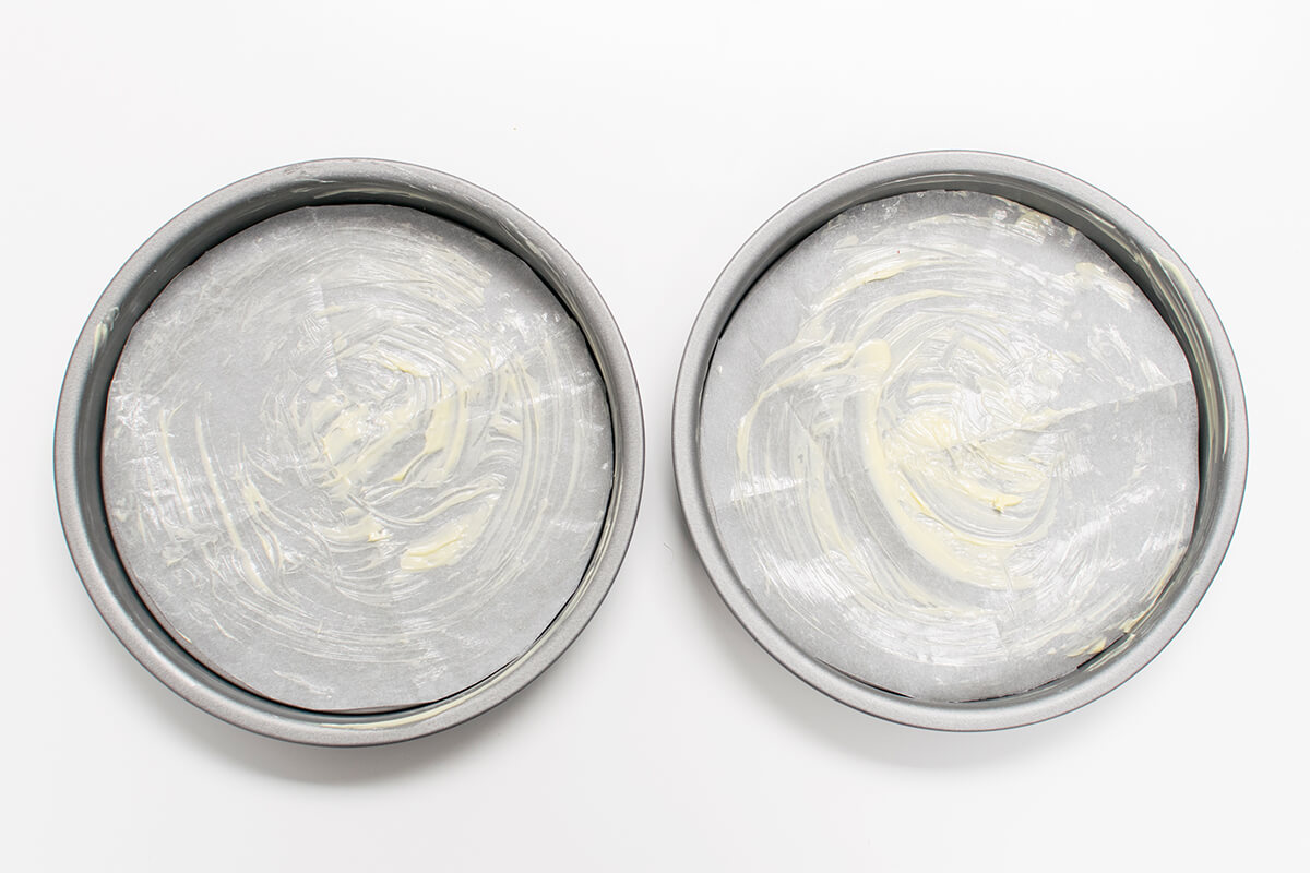 Two buttered cake tins