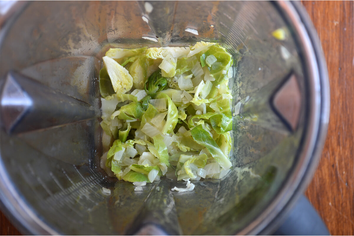 Cooked Brussels sprouts with garlic and stock in a blender