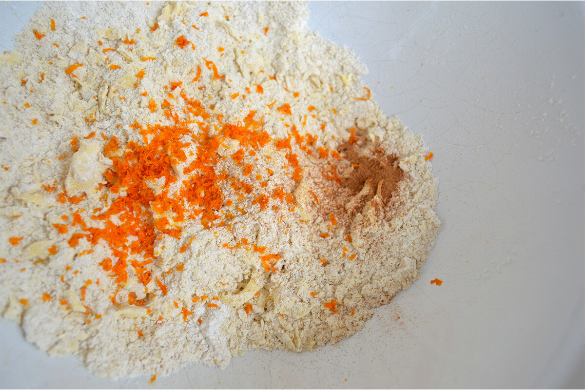A mixing bowl with flour and orange zest
