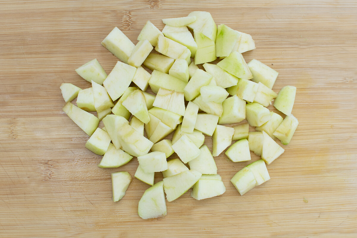 A chopping board with diced apple cubes