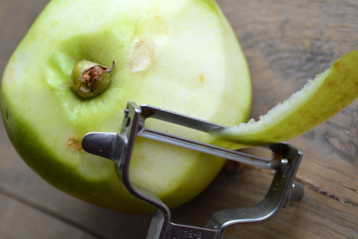A green apple being peeled