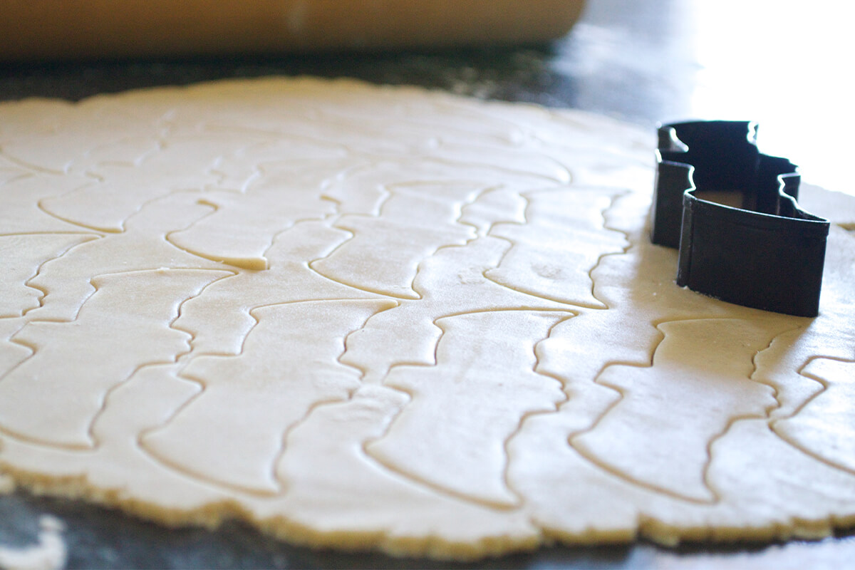 Biscuit dough being cut out with a bat shaped cutter