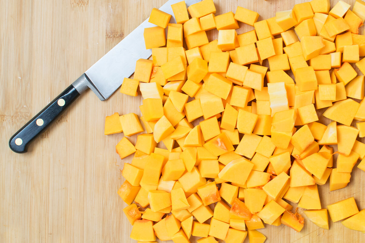 A chopping board with diced butternut squash
