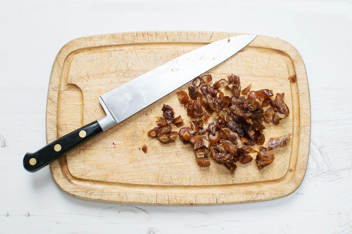 A chopping board with chopped dates