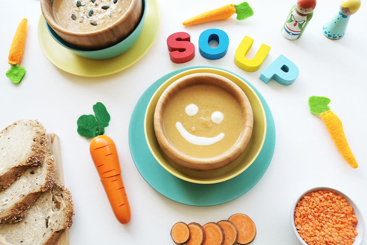 A bowl of lentil soup with a cream smiley face