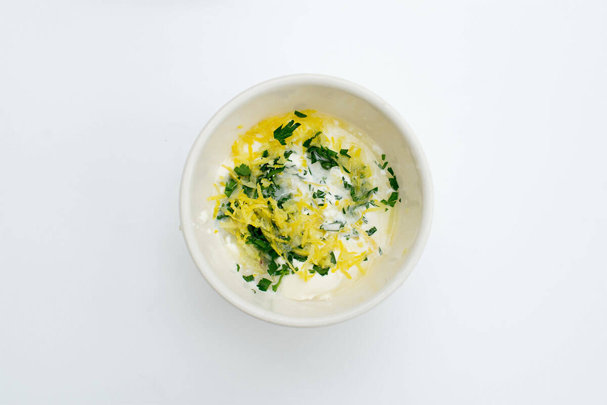 A bowl of crème fraiche with herbs and lemon zest