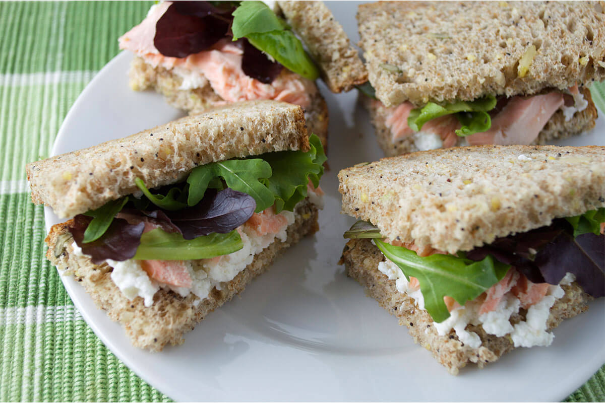 Salmon & Cream Cheese Sandwich with salad leaves cut into quarters