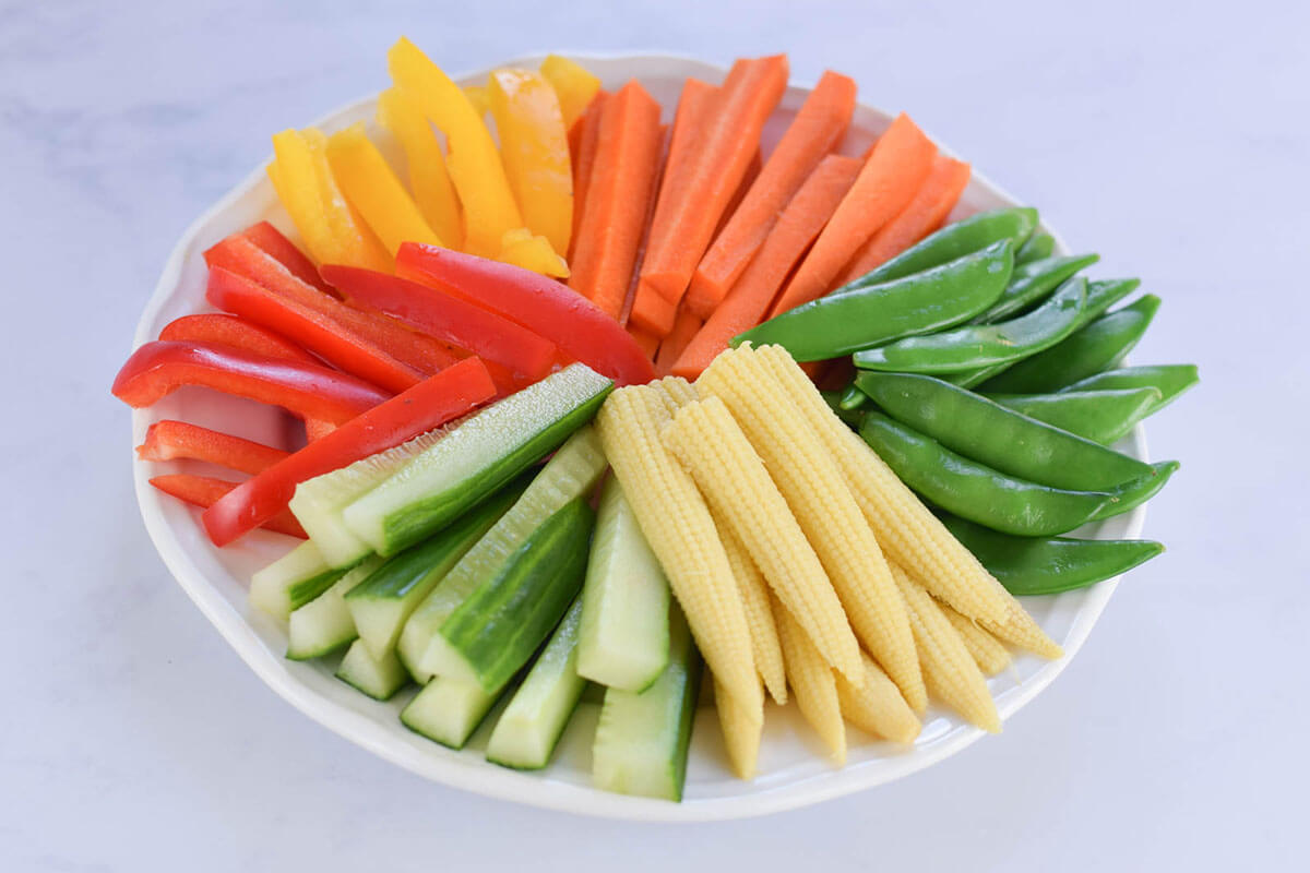 Rainbow Veggie Platter with carrot sticks, sugar snap peas, baby corn, cucumber sticks and sliced red and yellow peppers