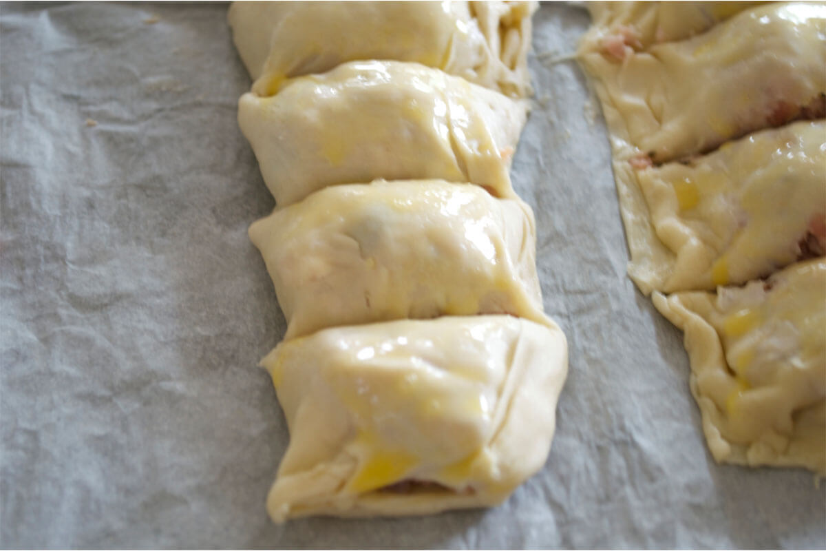 Sausage roll filling rolled into and covered in pastry cut into bite-sized pieces