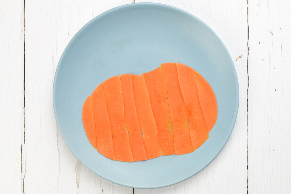 Blue plate with a pumpkin shape made of steamed carrot. 