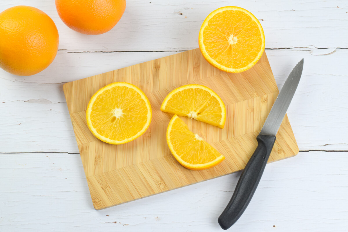 Chopping board and knife and thin slices of orange