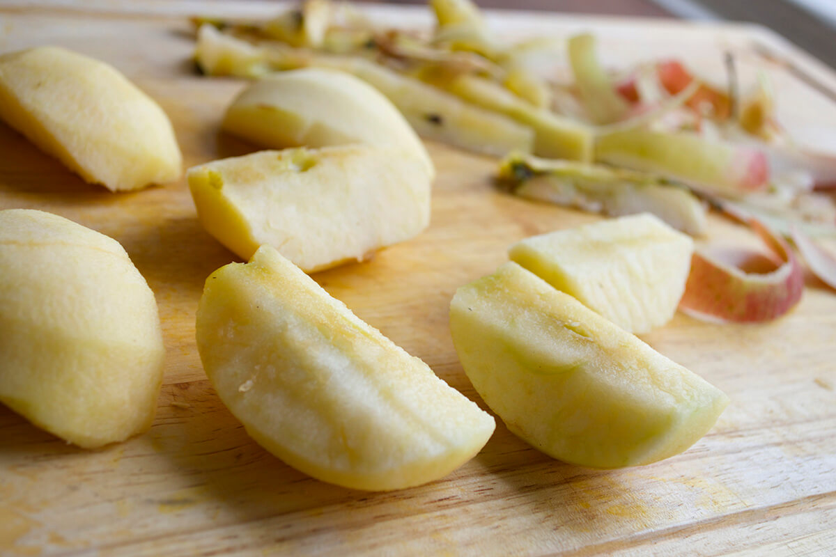 Cored and sliced apples on a chopping board