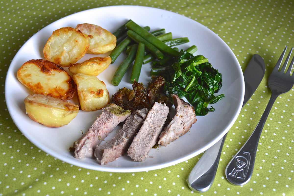 A serving of Apricot Stuffed Easter Lamb with roast potatoes, green beans and spinach