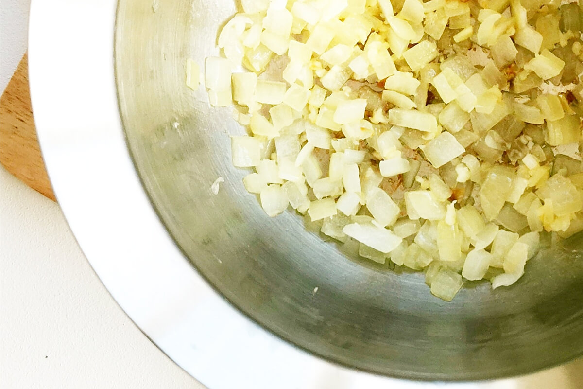 A pan with oil, diced onion and crushed garlic
