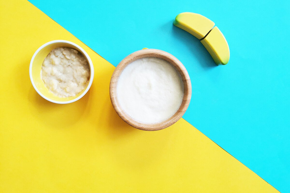 A bowl of Organix baby rice next to a small bowl of mashed banana