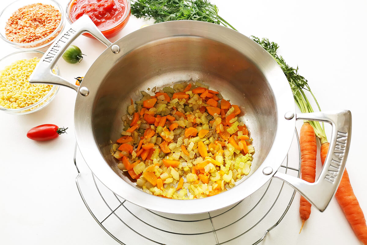 A pan of chopped onion, crushed garlic, carrots and celery