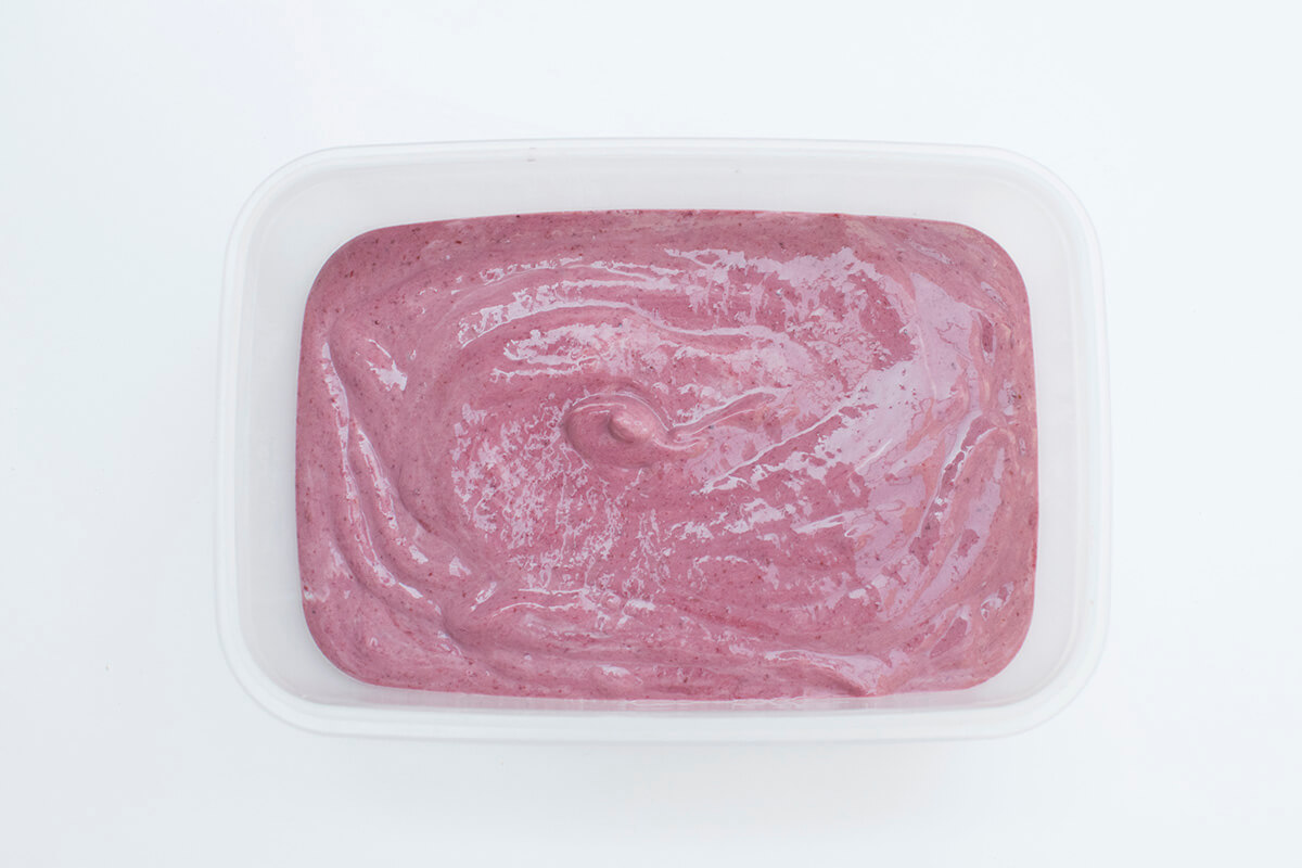 Blackberry and banana ice cream mix in a tub