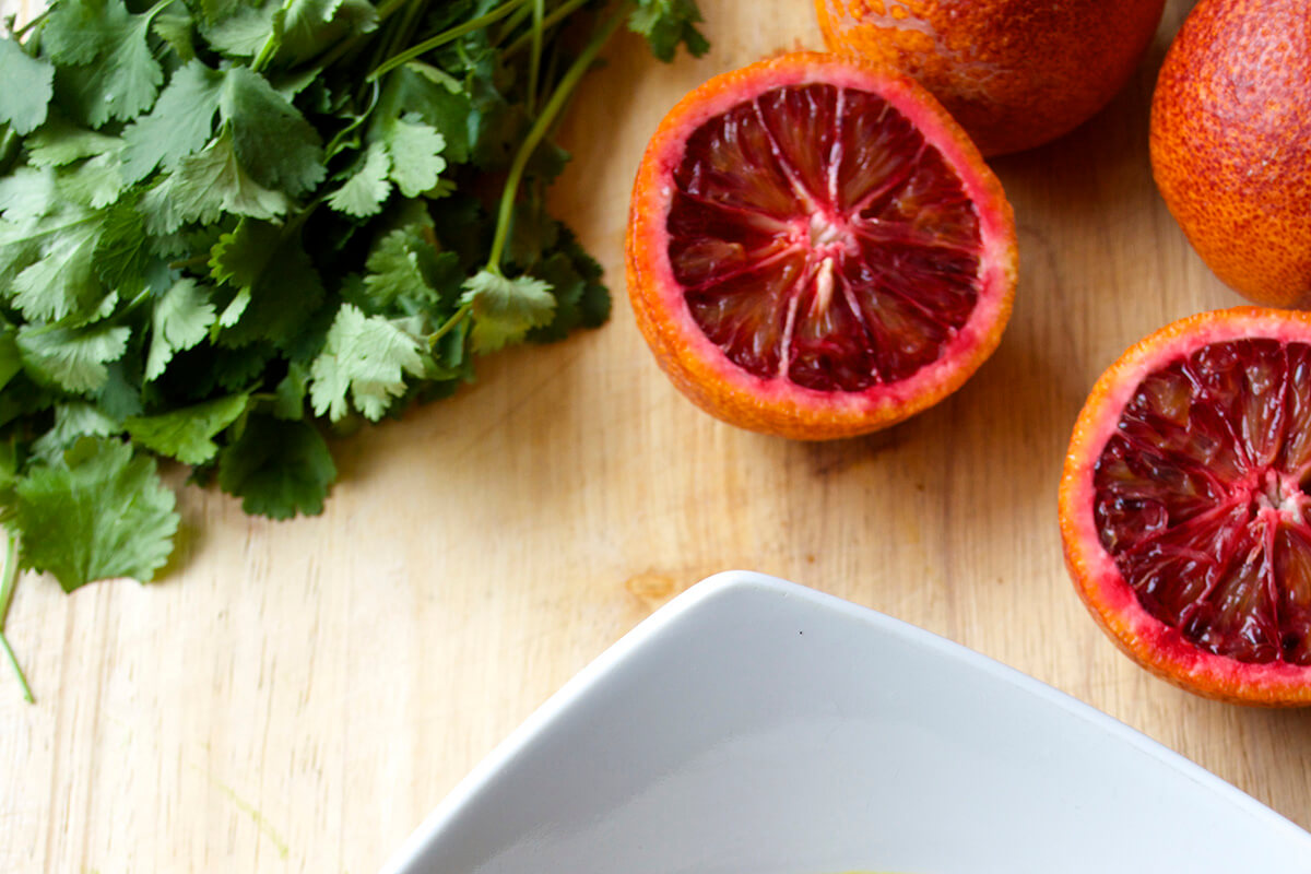 Halved blood oranges and a bunch of coriander