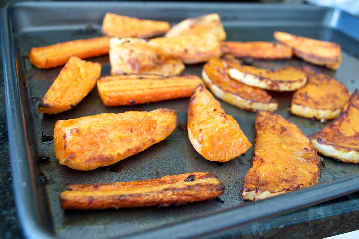 Roasted butternut squash and sweet potato on a roasting tray