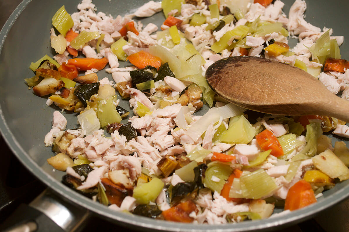 A saucepan of chopped vegetables fried with leeks and turkey/chicken