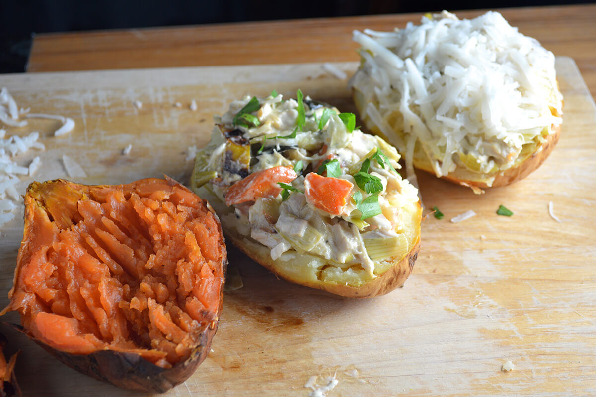 Halved jacket potato with filling and a sweet potato with no filling