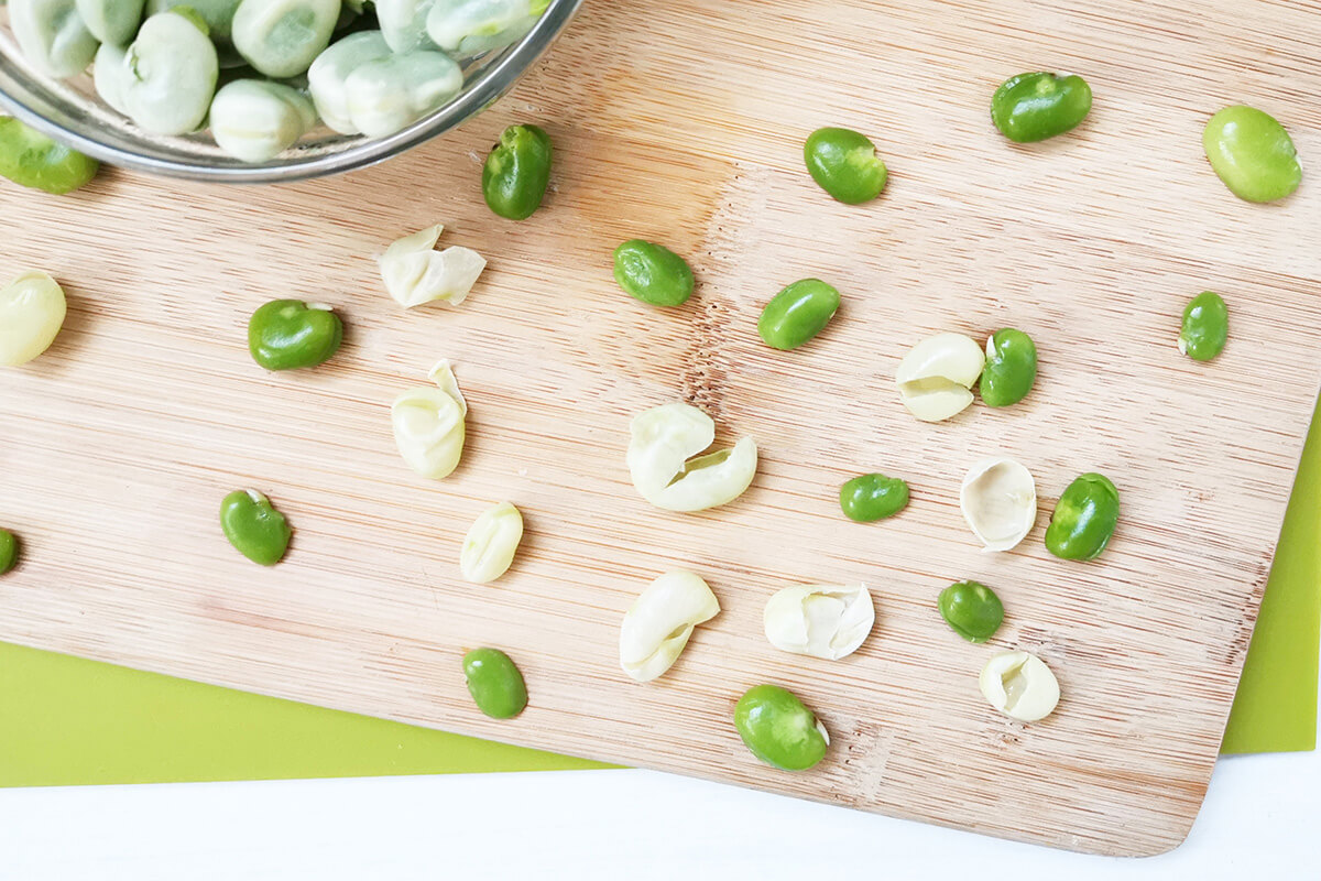 Peeled broad beans on a chopping board