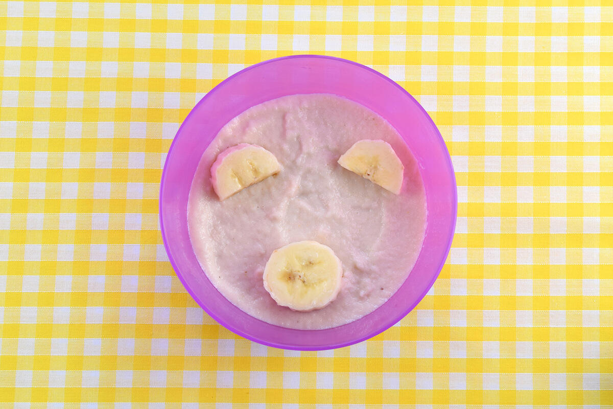 Banana slices placed on porridge. Two halves to make ears and a circle placed in the bottom centre of the bowl