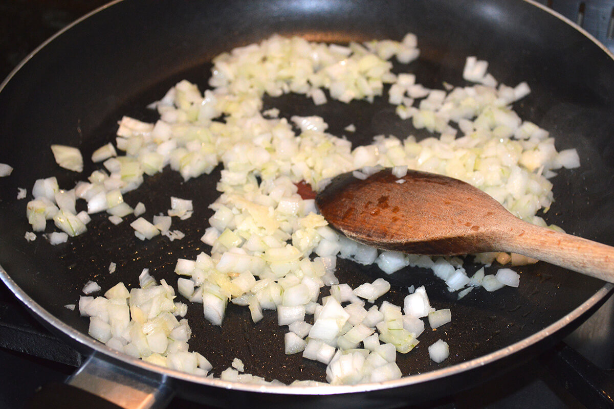 Onion being sauteed in a saucepan