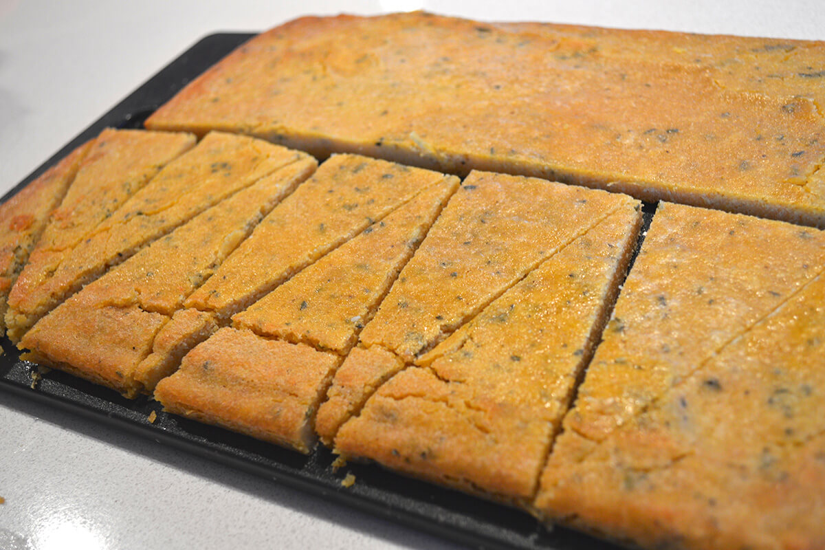 A baking tray with farinata bread sliced in half and into triangles