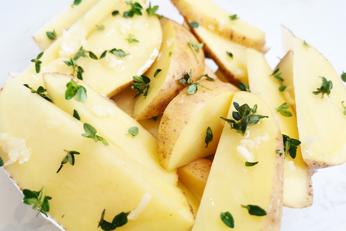 Potatoes cut into wedges and coated with crushed garlic and thyme