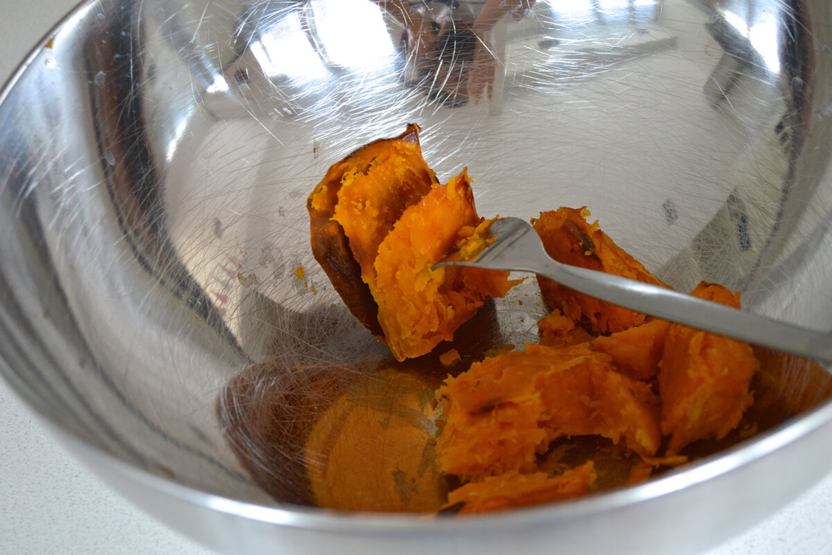 A bowl of butternut squash being mashed