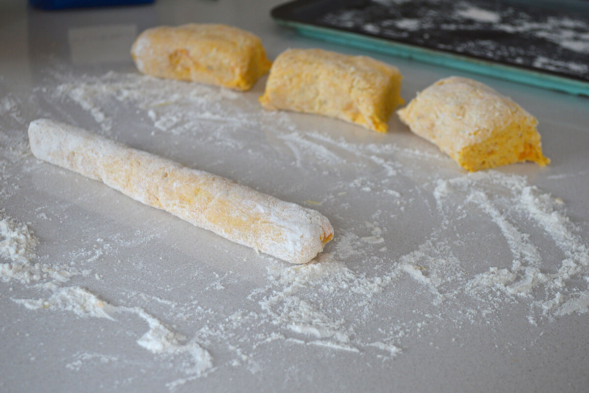 A floured work surface with gnocchi dough being rolled out