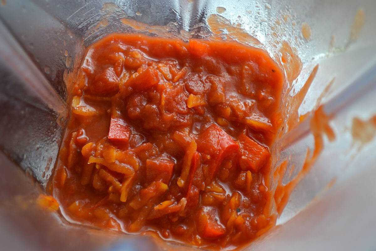 A food processor with chopped, tinned tomatoes